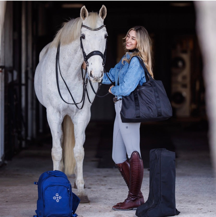 Allie Driver wearing the Veltri Sport Newport Tote with her horse and Veltri Sport Delaire Backpack and Bedford Boot Bag on the floor.