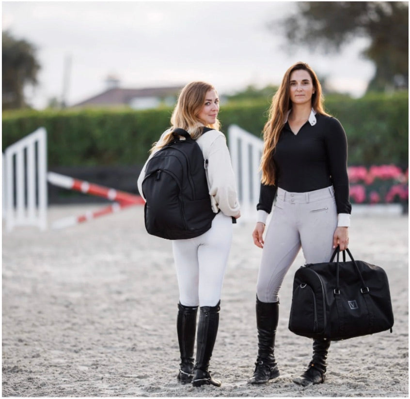 Two equestrian women carrying the Grande Backpack and the Ellis Garment Duffle