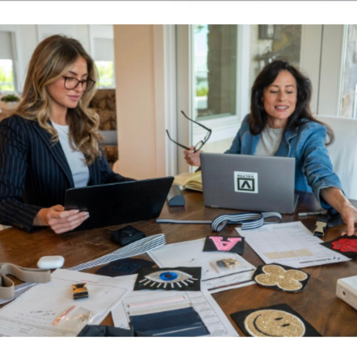Lisa and Alessandra Veltri at their work table communicating about new design ideas