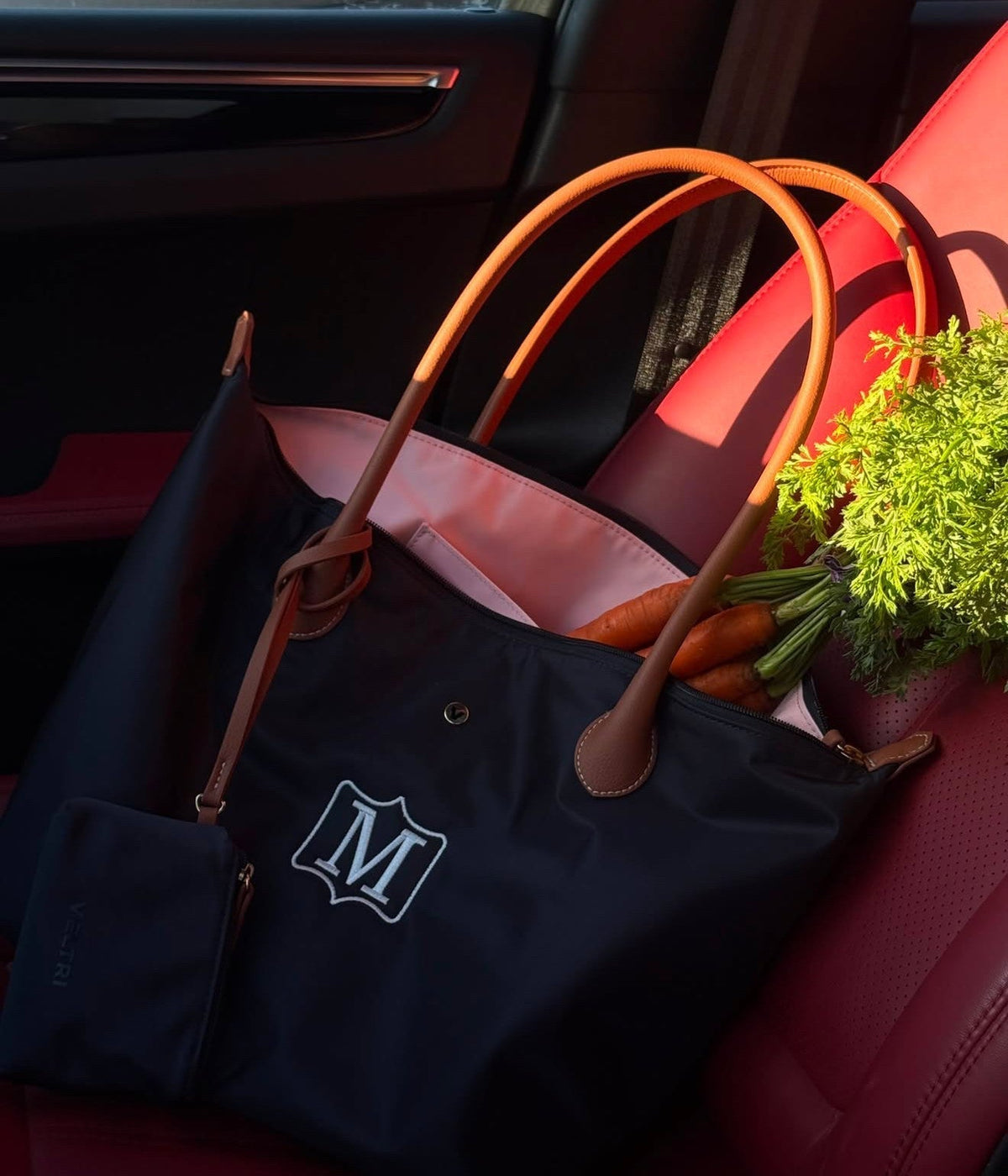 Veltri Sport's Sustainable Campus Tote in Navy in the passenger seat of a car.