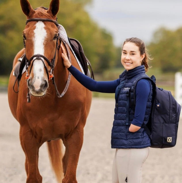 Lizzy Traband petting horse with Veltri Sport Grande Backpack on shoulder. 