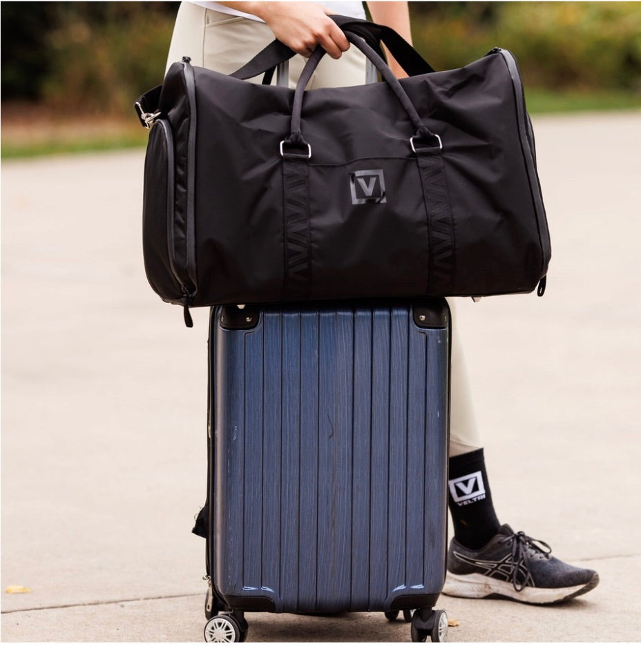 Veltri Sport Ellis Garment Duffle on top of suit case held by a women wearing Veltri Sport socks.