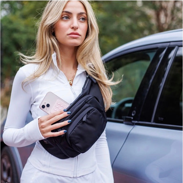 Women putting phone into Veltri Sport Thayer Cargo Bag.
