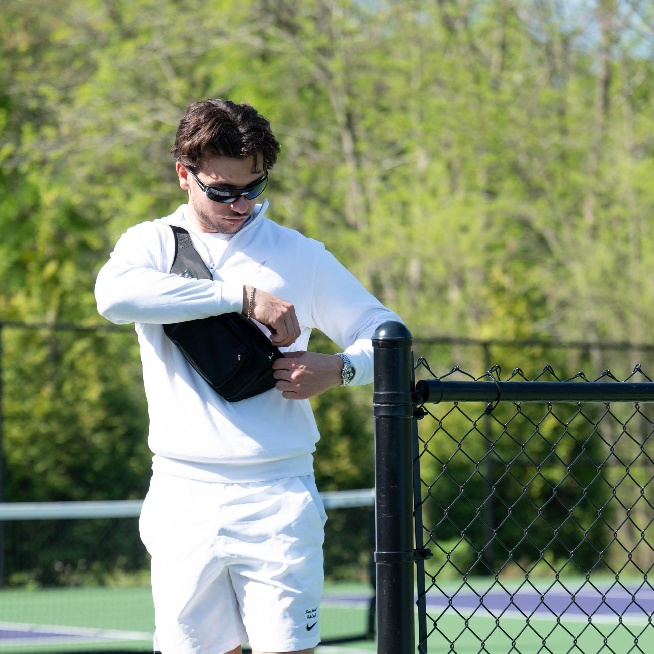 Veltri Sport Thayer Cargo Bag worn by a man leaving a tennis court, versatile hands-free bag for sports, travel, and everyday use